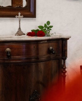Crucifijo plata apoyado en un mueble antiguo_Laura Rosselló