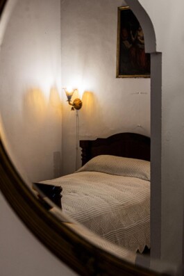 Reflejo del dormitorio en el espejo de la pared_Laura Rosselló